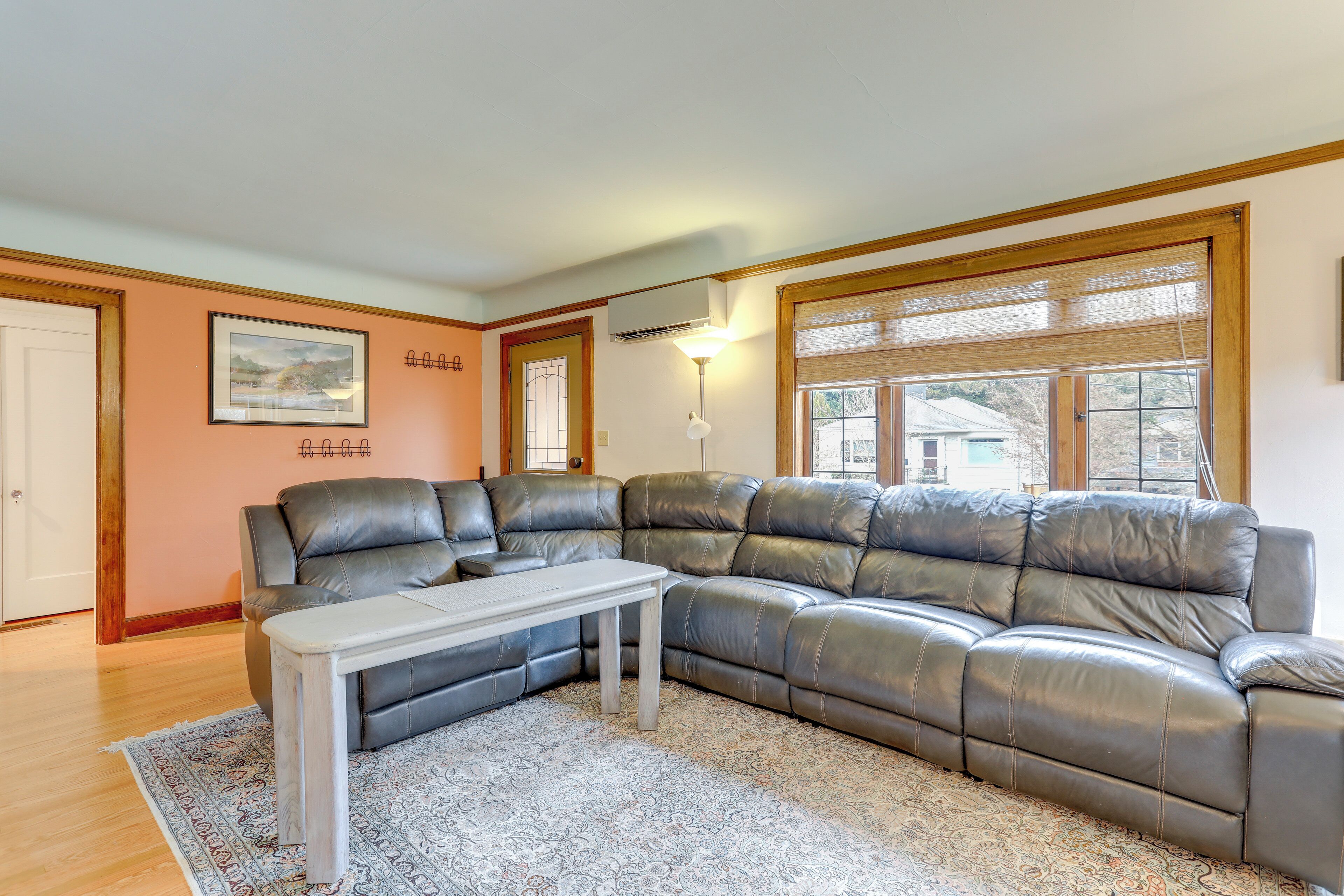 A modern living room with a sectional sofa, a small white table, and a patterned rug.