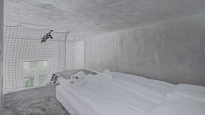 Una stanza con un letto, una zanzariera e un tavolino con asciugamani.