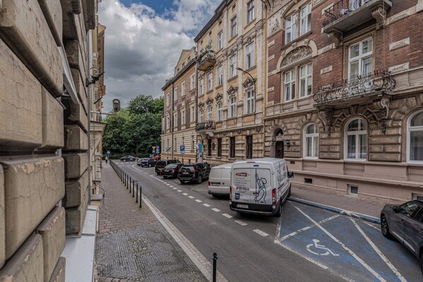 A street view with a row of historic buildings, a parking area with a disabled parking sign, and a van with a Britlux logo.