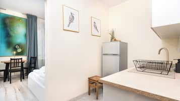 Standaard studio suite | Privékitchenette | Een koelkast, een oven, een kookplaat, kookgerei, borden en bestek