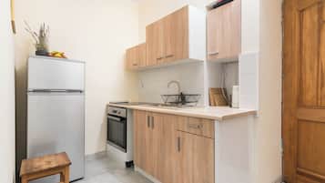 Standaard studio suite | Privékitchenette | Een koelkast, een oven, een kookplaat, kookgerei, borden en bestek
