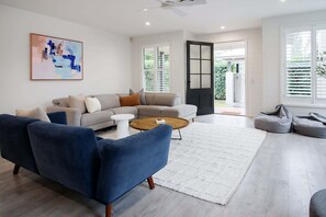A modern living room with a sofa, coffee table, and bean bag chairs.