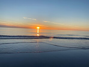 A beach with waves and a sunset. - Lapwing Cottage (South Uist)