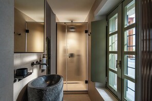 Bathroom features a large basin, wall-mounted faucet, and mirror above the sink.