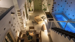 Eine Dachterrasse mit Pool, Sitzbereich und einer Treppe zu einer oberen Ebene.