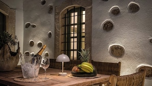 Ein Holztisch mit Champagnerflasche, Gläsern und einer Obstschale.