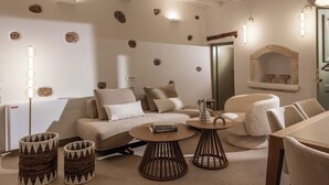 Ein modernes Wohnzimmer mit einer Couch, zwei Beistelltischen und einem Esstisch.