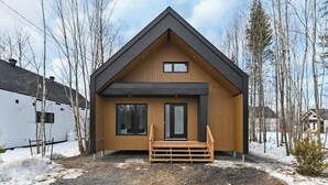 A modern house with a wooden exterior, a front porch, and a large window. - Trinity - Familiale - Spa & Nature by Alchalet (Pont-Rouge)