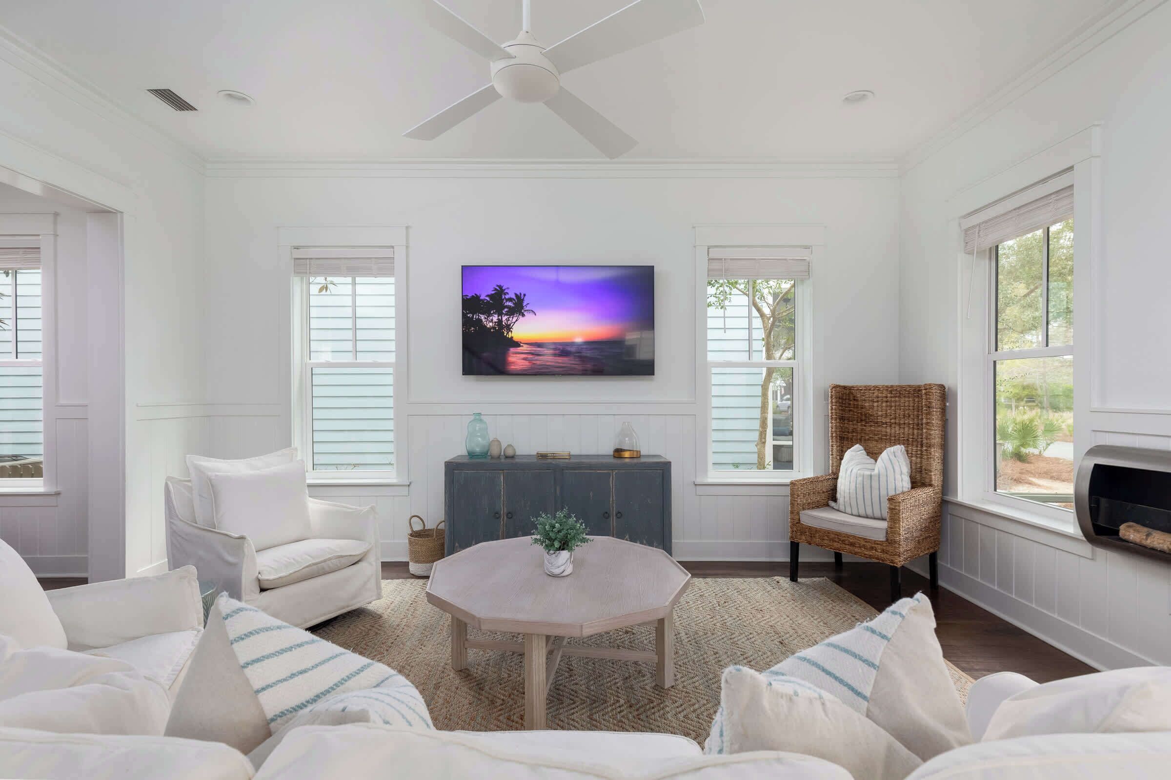 A spacious living room with a large TV, comfortable seating, and a fireplace.