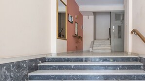 A marble staircase leading to a door with a metal handle. - Acropolis Hideaway Studio by GHH (Athina)