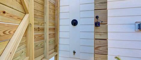 A wooden fence with a door, a window, and a mailbox.