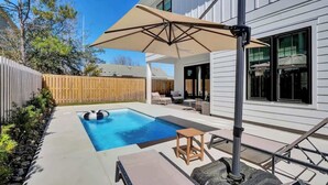 A backyard with a swimming pool, outdoor furniture, and a pergola. - Brezza Fresca w/ a private pool In Carolina Beach (Wilmington)
