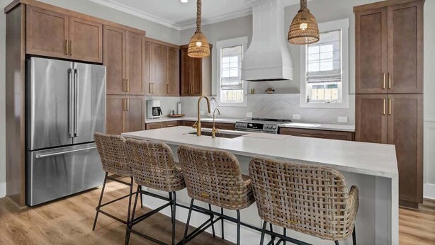A modern kitchen with a central island, stainless steel appliances, and wicker bar stools. - Brezza Fresca w/ a private pool In Carolina Beach (Wilmington)