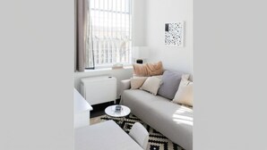 Una sala de estar moderna con un sofá, una mesa de centro y una lámpara.