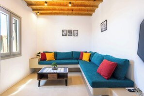 Una sala moderna con un sofá modular, una mesa de centro y techo de madera.