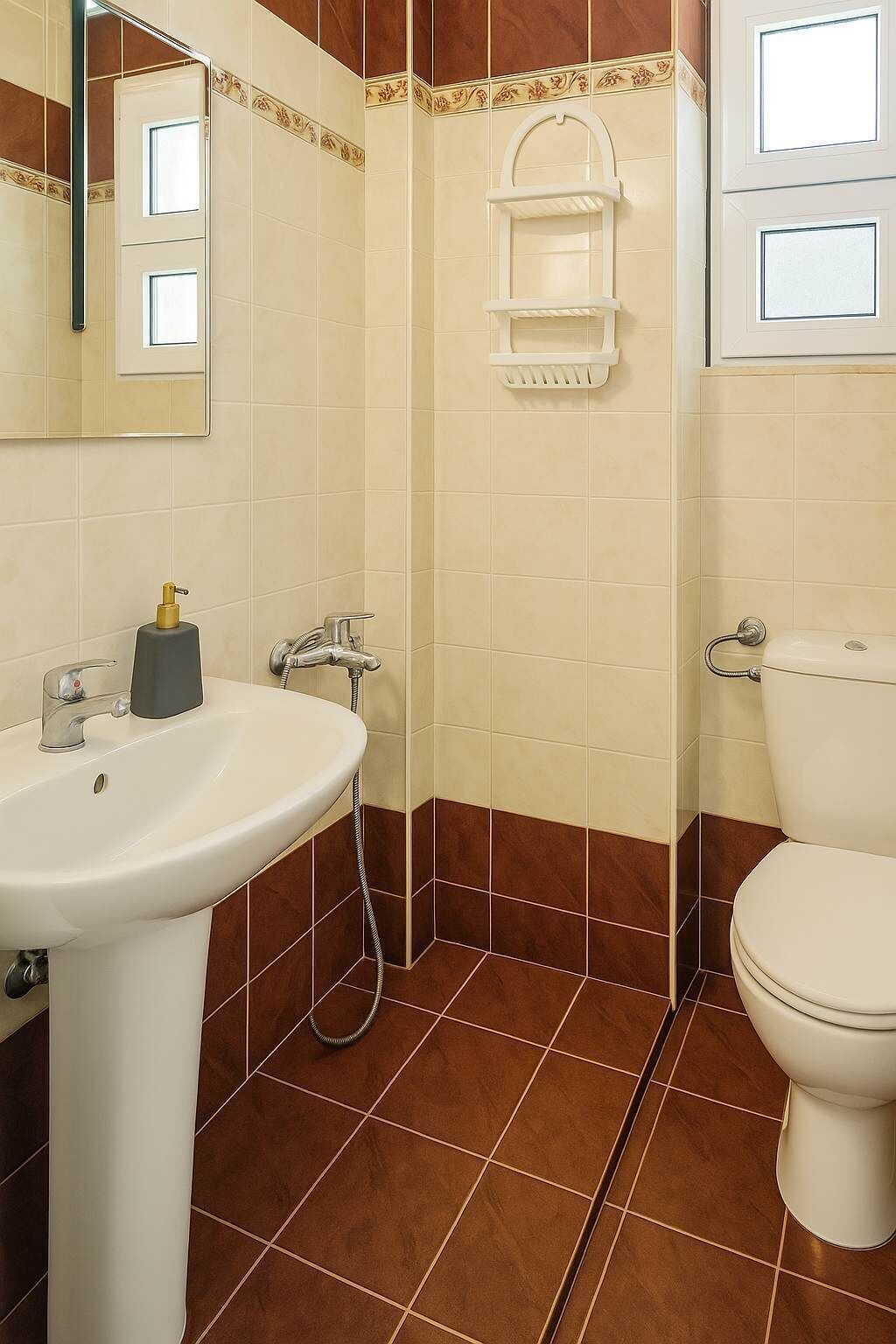 A bathroom with a white sink, a toilet, and a shower area.