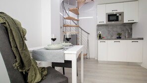 A modern kitchen with white cabinets and a stainless steel microwave.