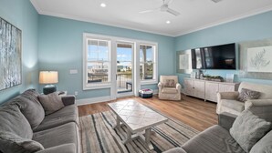 A living room with a sofa, armchairs, a coffee table, and a TV. - Beach Facing, 4Bd, Sleeps 10, Bikes, BBQ, Pool (Gulf Shores)