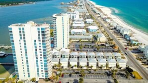 A coastal hotel with multiple buildings, a beachfront, and a parking area.