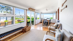 A spacious room with large windows, a ceiling fan, and a view of the outdoors. - Paradise Awaits you!  Sleeping 14, this oceanfront complex is perfect! (Dennis Port)