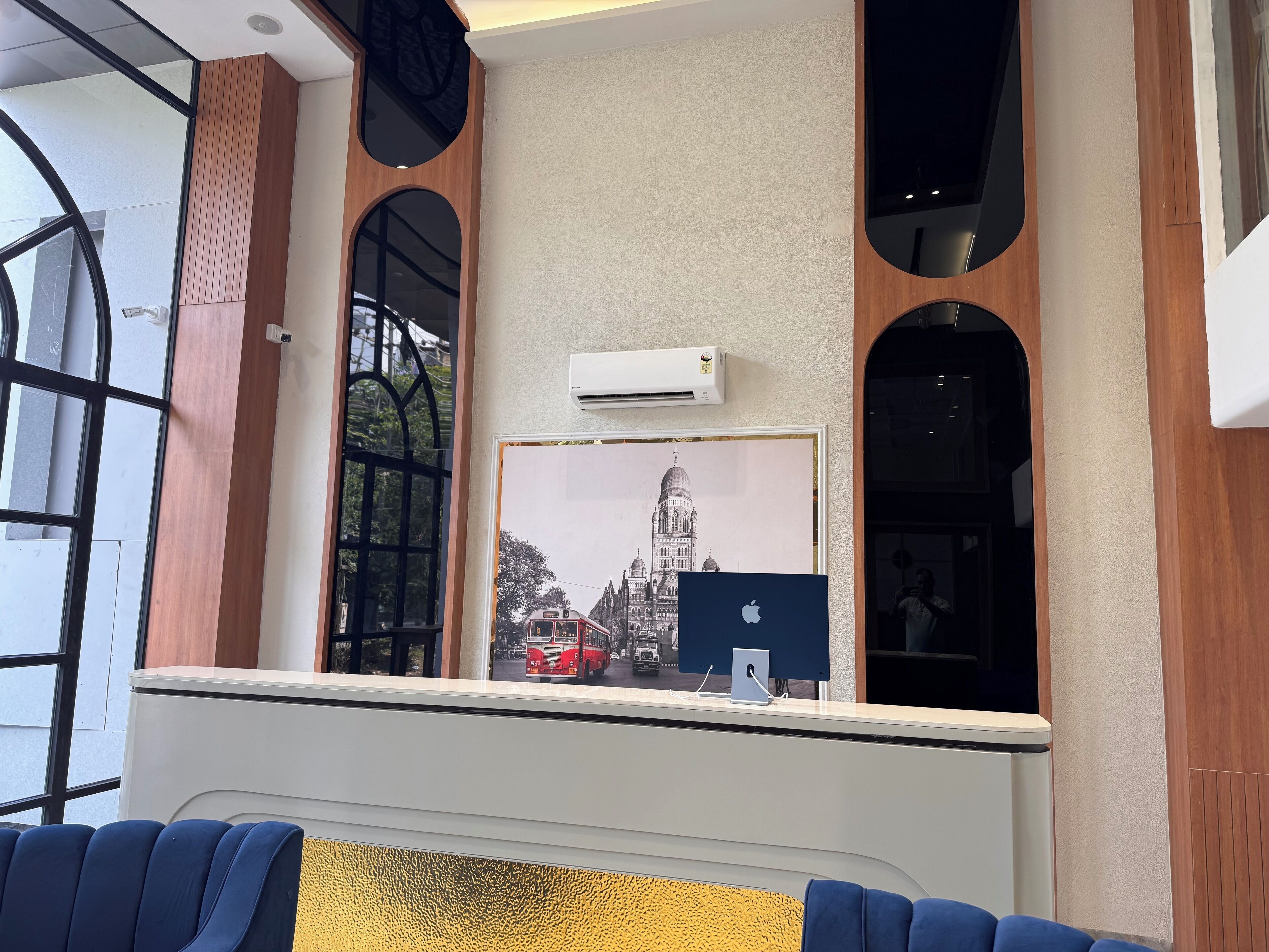 Ein Empfangsbereich mit einem großen Fenster, einer Klimaanlage und einem gerahmten Bild einer Kathedrale.