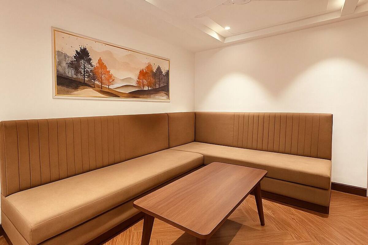 A modern room with a sectional sofa, a wooden coffee table, and a painting on the wall.