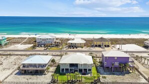 Una propiedad frente a la playa con varias casas, una playa al fondo y una vista despejada del océano.