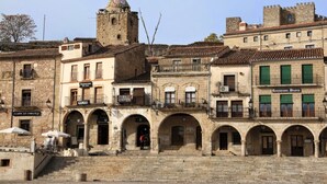 A historic town square with stone buildings, a clock tower, and a restaurant. - SINGLE ROOM IN THE MAIN SQUARE OF TRUJILLO (Trujillo)