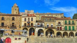 A historic building with multiple arches and a tower. - SINGLE ROOM IN THE MAIN SQUARE OF TRUJILLO (Trujillo)
