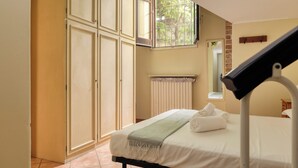 A hotel room with a bed, a window, a radiator, and a mirror. - JOIVY Charming flat in Porta Romana (Milan)