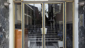 A building entrance with a glass door and a staircase leading inside. - Acropolis Museum Retreat by GHH (Athens)