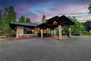 A building with a covered entrance and a paved courtyard. - Debu's The Fern Resort & Spa Jim Corbett, Series by Marriott (Ramnagar)