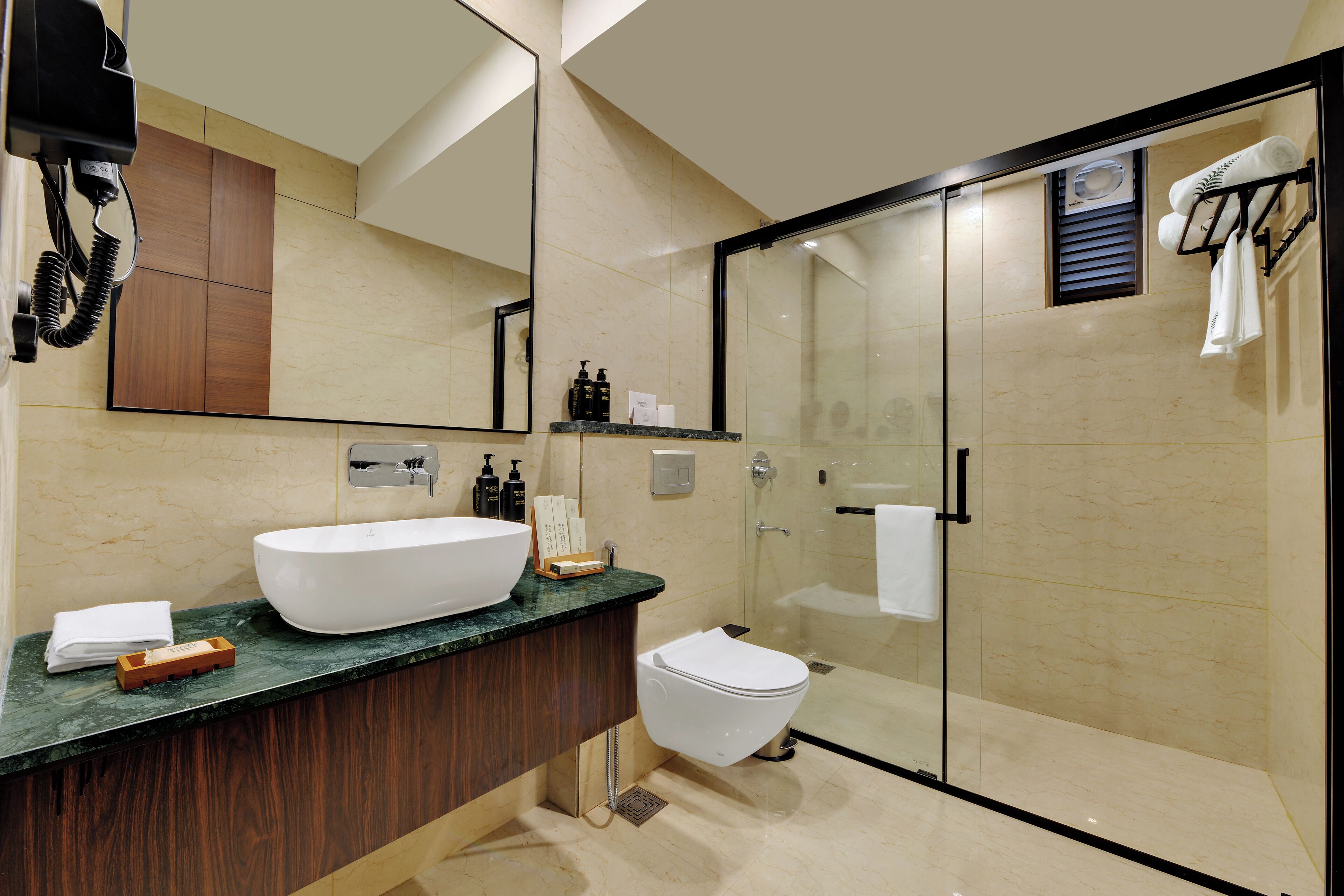 A modern bathroom with a large white sink, dark wood vanity, and a glass-enclosed shower area.