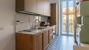A modern kitchen with wooden cabinets, a marble countertop, and a built-in oven.