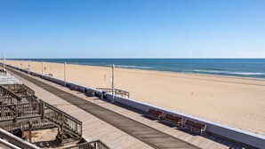 A wooden boardwalk leading to a sandy beach with a clear blue sky. - 3 Bed/2 Bath Boardwalk Oceanfront at Ocean Beach (Ocean City)