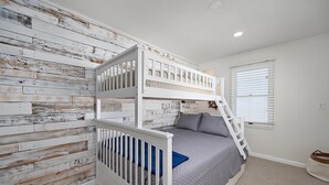 A bunk bed room with a rustic wooden wall, a window with blinds, and a small rug. - 3 Bed/2 Bath Boardwalk Oceanfront at Ocean Beach (Ocean City)