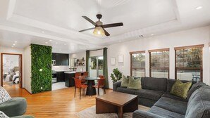 A modern living room with a sofa, coffee table, and dining area.