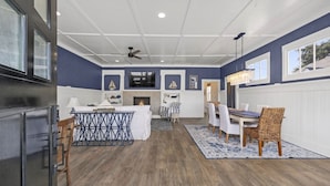 A spacious living area with a fireplace, dining table, and chairs. - Game Room, Dogs Ok, Walk to Beach (Breakaway) (Ocean Park)