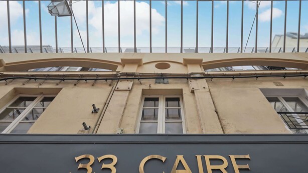 A building facade with the number '33' and the word 'CAIRE' indicating the address.