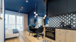 Eine moderne Küche mit Essbereich, Holzboden und einer blauen Akzentwand.