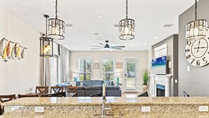 A modern kitchen with granite countertops, stainless steel sink, and pendant lighting. - Beach House Spacious 4BR Retreat With Gulf Views & Observation Deck! (Panama City Beach)