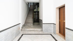 A staircase leading to a wooden door, with a tiled floor and a white wall. - Umbertina Cozy Apartment by Wonderful Italy (Bari)