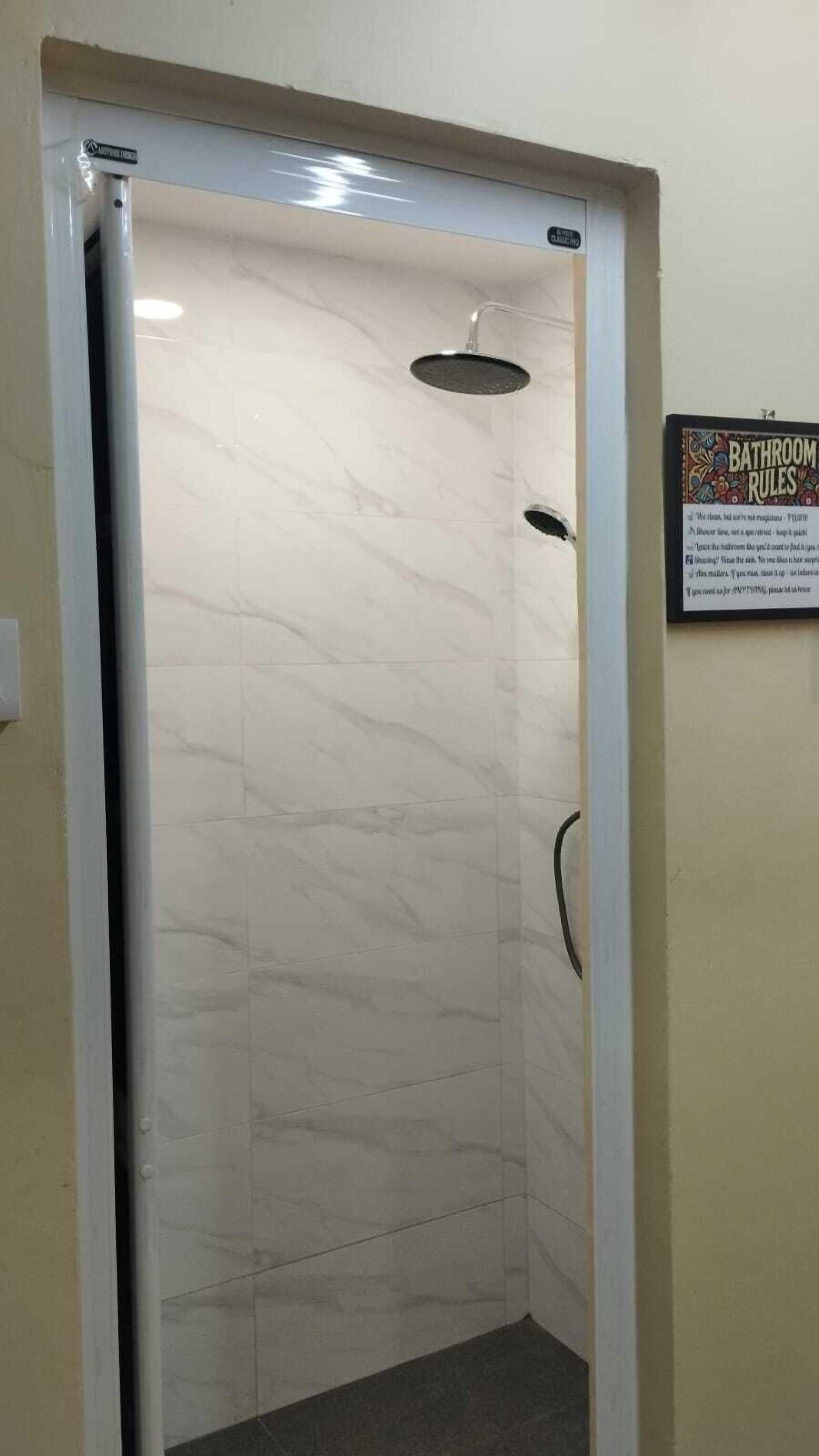 A bathroom with a shower, a sign with bathroom rules, and a marble floor.