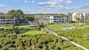 A modern hotel complex with multiple buildings, a parking area, and well-maintained green spaces. - Beachfront Condo with Communal Pool & Ocean Views! (Hilton Head Island)