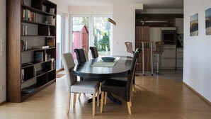 Ein Essbereich mit einem runden Tisch, Stühlen und einem Bücherregal.