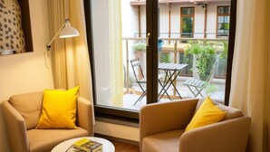 A cozy room with two sofas and a small table, a window with a view of a balcony and outdoor furniture. - Urban Krakow Escape: Balcony, Quiet Retreat & City Center Access (Kraków)