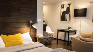 A modern hotel room with a bed, a desk, a chair, and a sofa. - Urban Krakow Escape: Balcony, Quiet Retreat & City Center Access (Kraków)