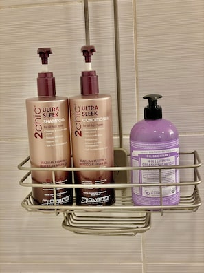 A metal shelf with two bottles of Ultra Sleek Shampoo and Conditioner, and a bottle of Dr. Bronner's soap. - Cozy Cottage in Todd - Hot Tub, Outdoor Oasis (Todd)
