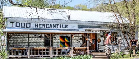 Un edificio rústico con un letrero que dice "TODD MERCANTILE" y un letrero de "PANADERÍA".