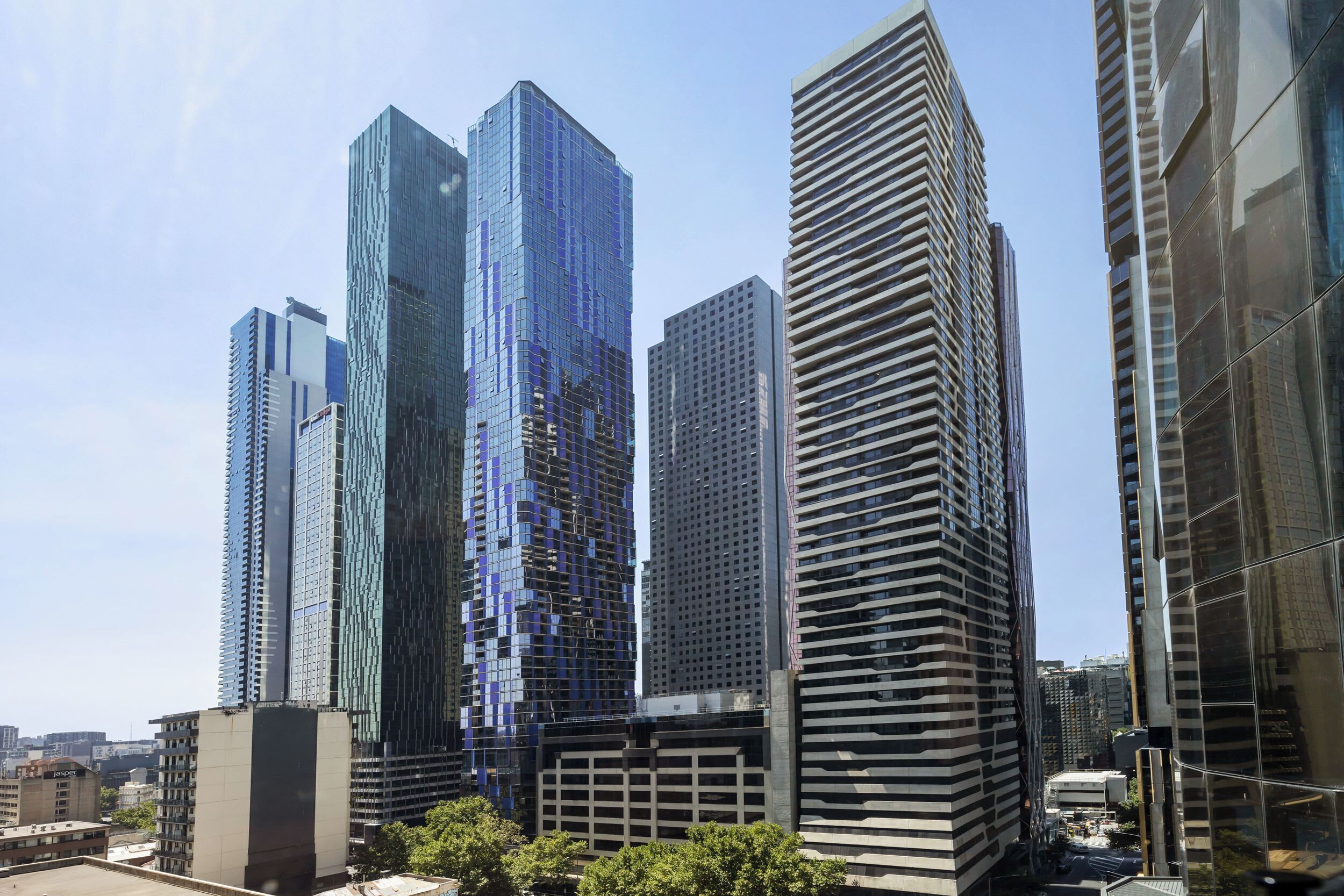 Een groep moderne hoogbouwgebouwen met reflecterende glazen gevels, waarschijnlijk onderdeel van een zakendistrict.